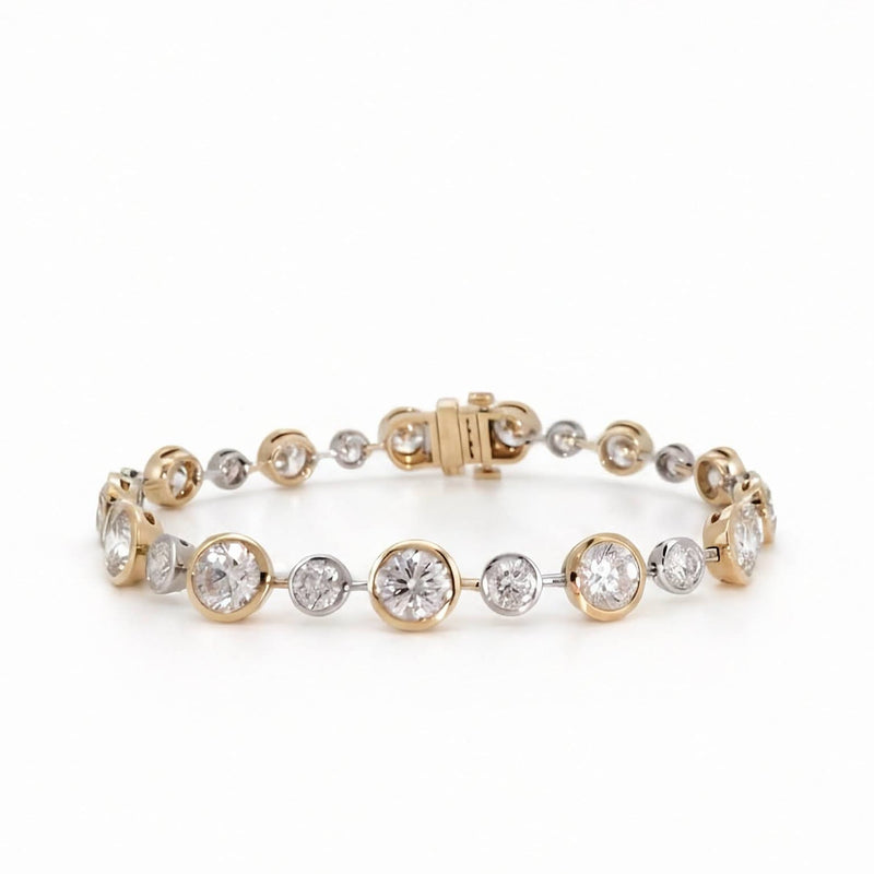A yellow  and white gold bezel set round diamond bracelet  on a seamless white background.
