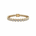 A yellow gold bezel set  bracelet featuring round-cut lab grown diamonds in bezel settings, displayed on a clean white background.