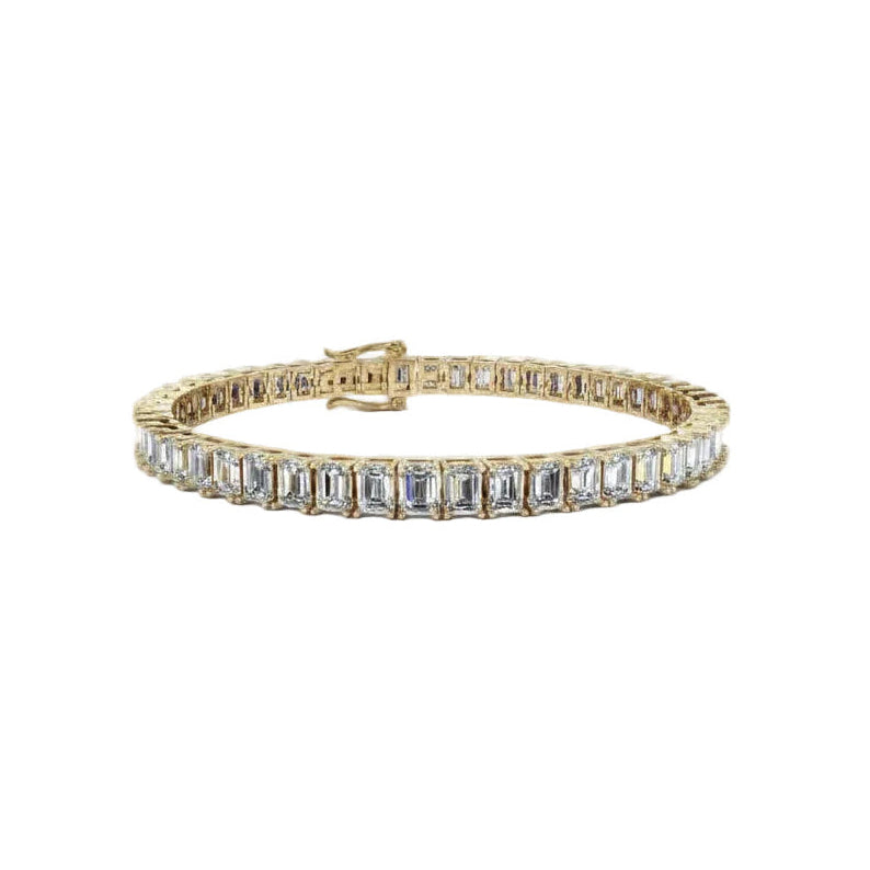 A yellow gold tennis bracelet featuring a row of baguette-cut diamonds, displayed against a solid white background.