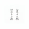 A pair of white gold drop earrings featuring a oval-cut lab grown diamonds in a prong setting on the top and a pear-cut clear gemstone in a prong setting below, shown against a plain white background.