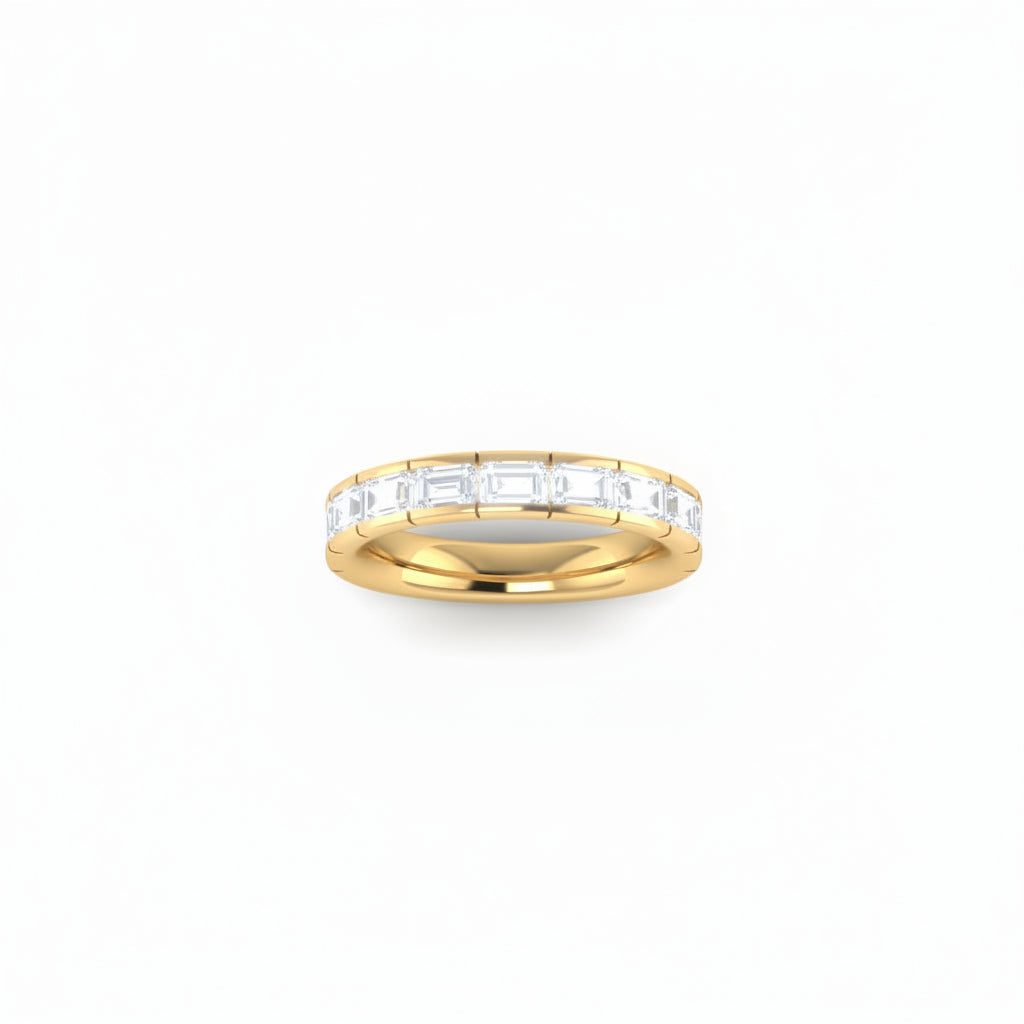 A yellow gold eternity ring featuring a row of east-west set baguette-cut lab grown diamonds, shown on a plain white background.

