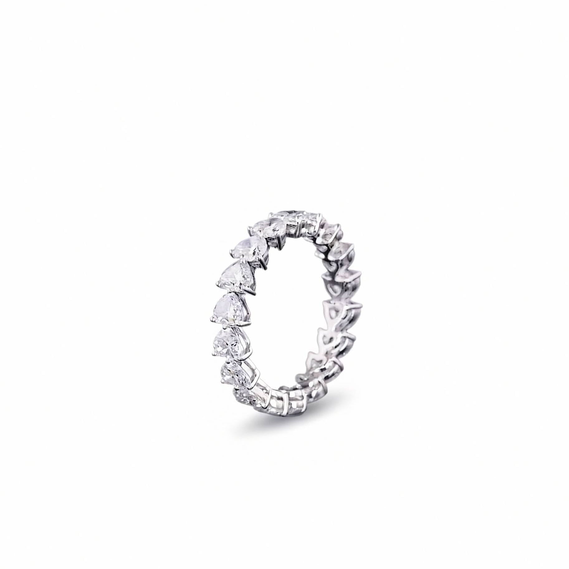 A white gold diamond eternity band ring featuring a continuous row of Heart Shaped-cut lab grown diamonds set in a polished silver-colored metal, shown against a plain white background.