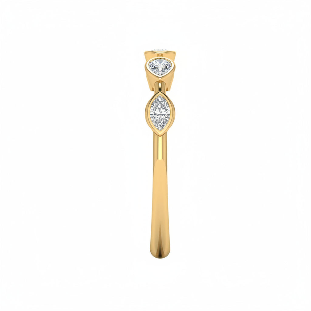 A delicate yellow gold ring featuring five small multi shaped-cut lab grown diamondsin spaced out setting, diamonds 1/2 in a row, photographed on a clean white background with side ring view.