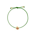 A green adjustable cord bracelet featuring a small yellow gold apple charm embellished with purple gemstones, set against a plain white background.