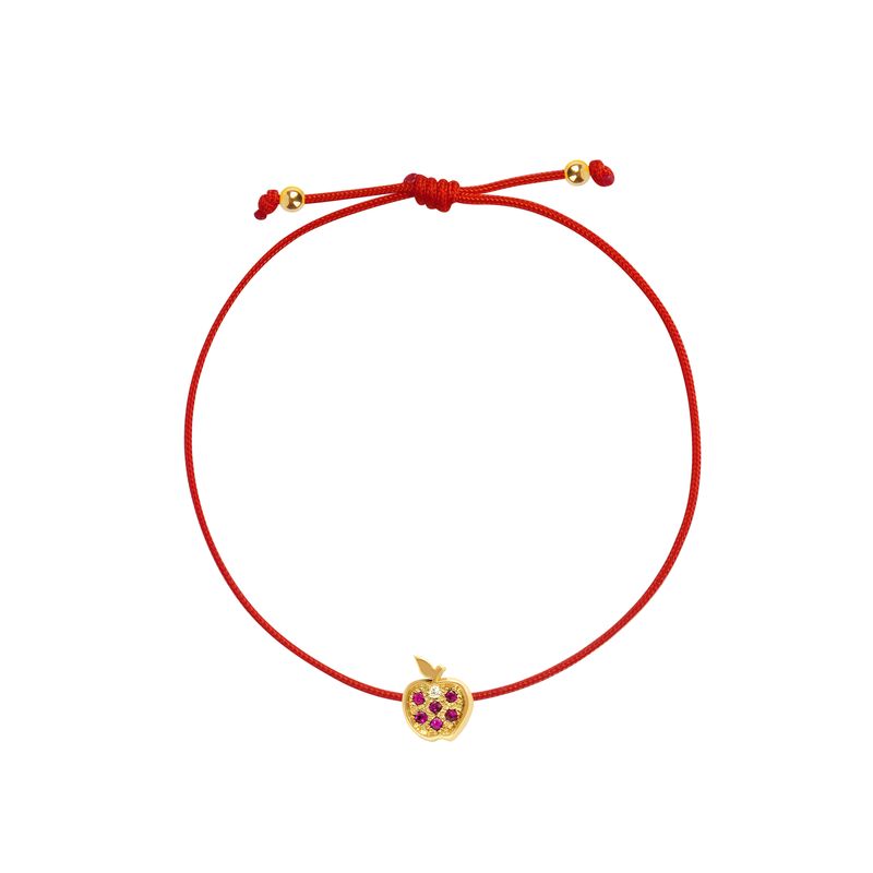 A red cord bracelet featuring a small gold apple charm embellished with purple gemstones, displayed on a clean white background.