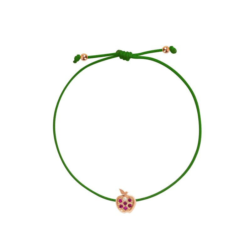 A green adjustable cord bracelet featuring a small rose gold apple charm with purple gemstone accents, displayed on a clean white background.