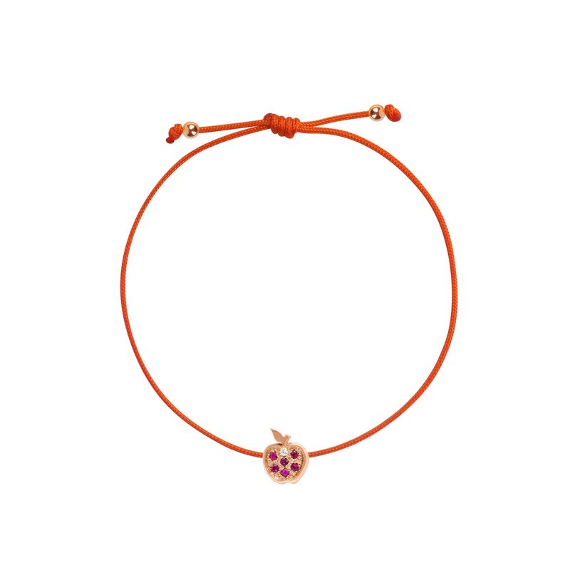 An orange cord bracelet featuring a small rose gold apple charm set with purple crystals, displayed on a clean white background.
