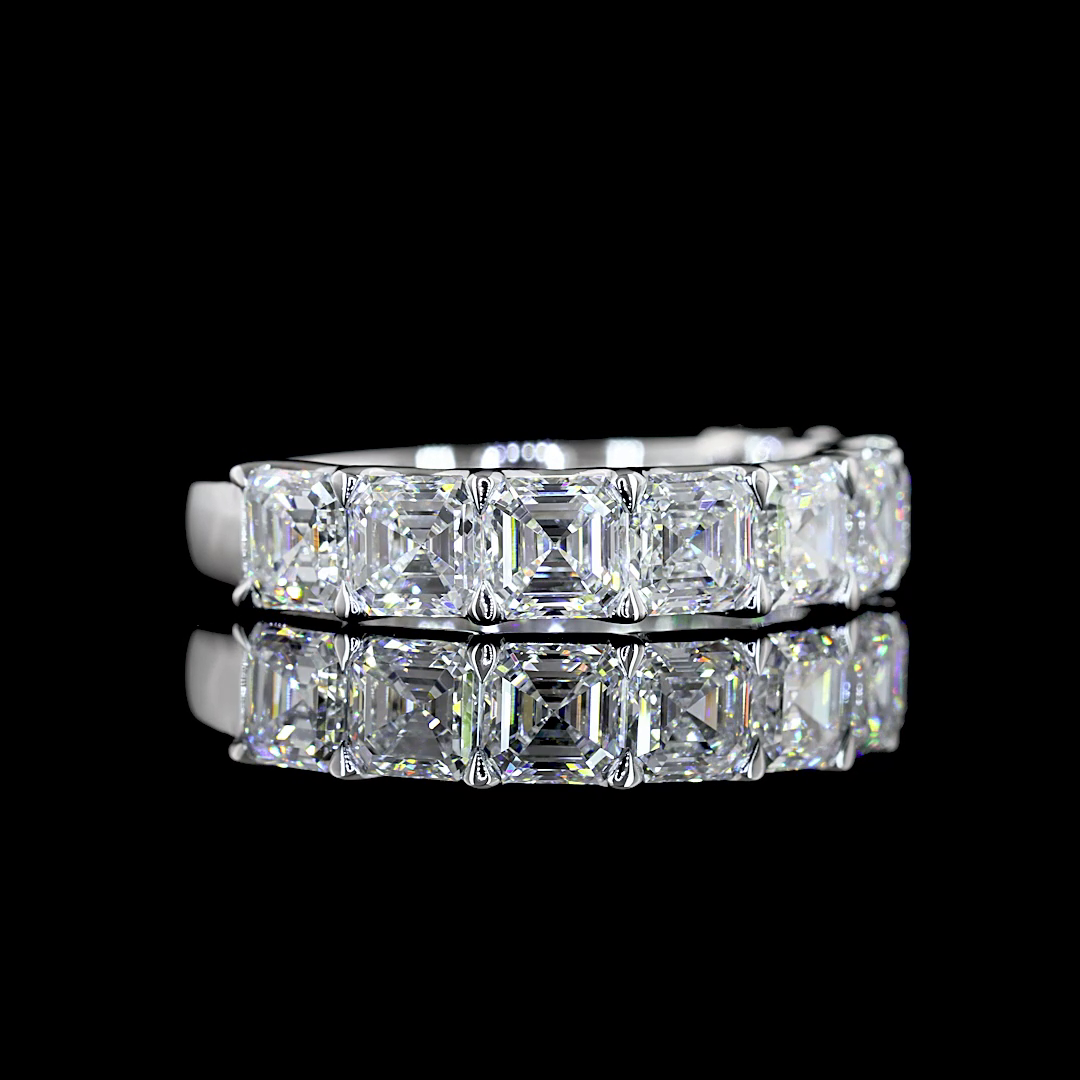 A white gold Asscher Diamond Prong set 1/2 eternity ring featuring a continuous row of asscher cut lab grown diamonds, shown on a clean black background.