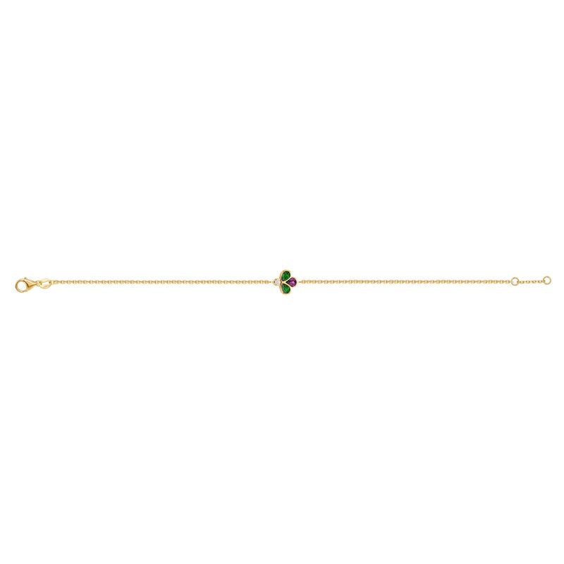 A gold chain bracelet featuring a central clover charm with green and purple stones, set against a plain white background.