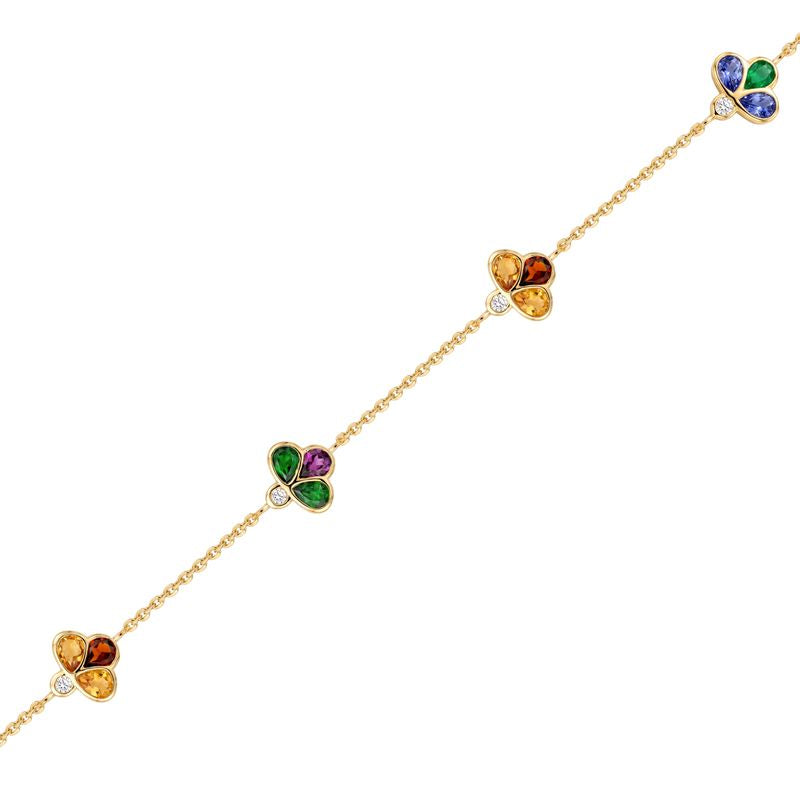A delicate gold chain bracelet featuring four small clover motifs in different colors (orange, green, yellow, purple) spaced evenly along the chain, set against a plain white background.