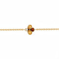 A delicate yellow gold chain bracelet featuring a central clover-like charm with two yellow gemstones, one amber-orange gemstone, and a small clear accent diamond, shown on a plain white background.