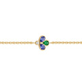 A delicate yellow gold chain bracelet featuring a central clover motif. The left and right clover petals are set with pear cut blue gemstones, while the center petal is set with a vibrant green color and a round diamond at the top.