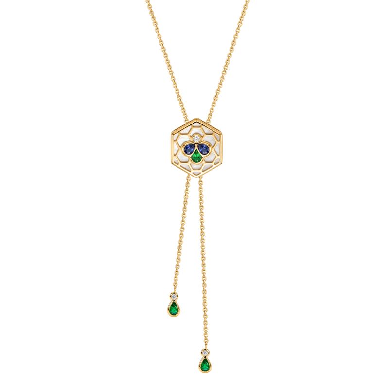 A yellow gold chain necklace with a hexagonal pendant featuring a white center, a small clear stone, three-stone clover motif in blue, green, and gold and dangly chain extension with round diamond and pear green stone.