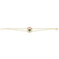 A delicate gold double chain bracelet featuring a central hexagonal charm with a green and blue stone cluster, set against a plain white background.