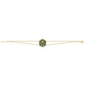 A delicate gold double chain bracelet featuring a central hexagonal charm with a green and red floral pattern, set against a plain white background.