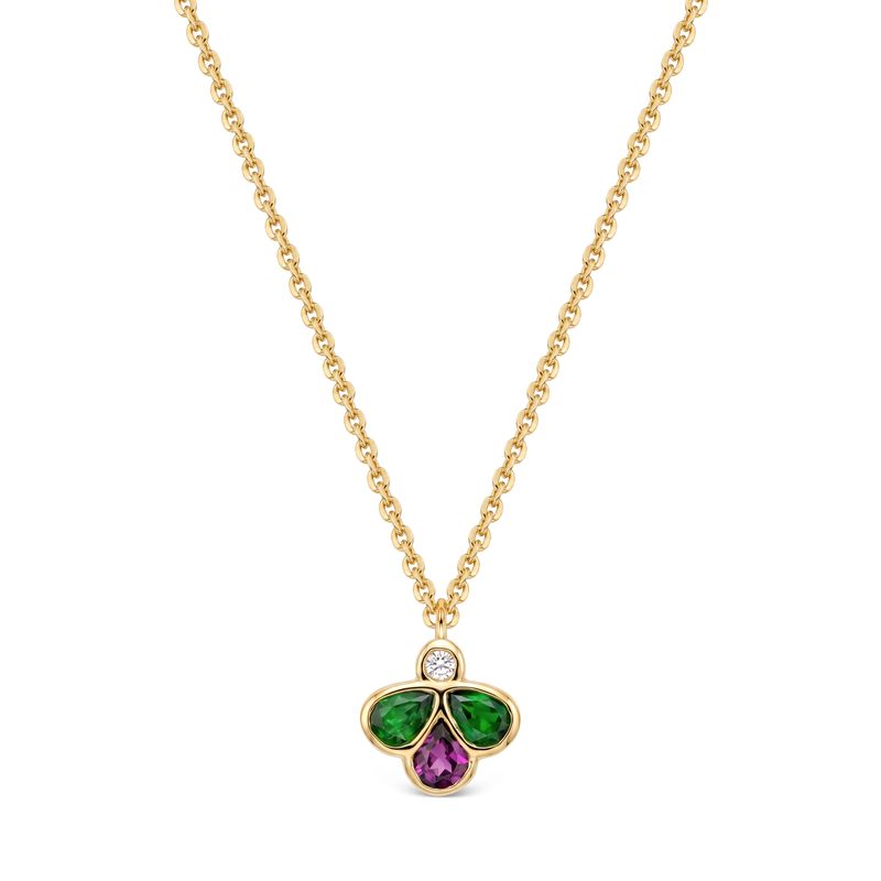 A gold chain necklace with a clover-shaped pendant featuring a small round diamond at the top, a green teardrop-shaped stones on the left and right, and a purple teardrop-shaped stone in the midlle, set against a plain white background.