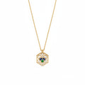 A gold chain necklace with a hexagonal pendant featuring a white center, a small clear stone, and a three-stone clover motif in blue, green, and gold.
