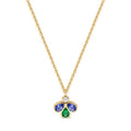 A gold chain necklace with a small clover-shaped pendant featuring a central round diamond, a two blue gemstones, and a bottom green teardrop gemstone, shown on a plain white background.