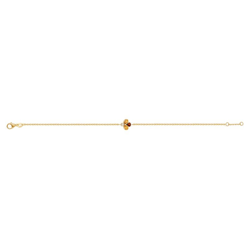 A delicate yellow gold chain bracelet featuring a central clover-like charm with two yellow gemstones, one amber-orange gemstone, and a small clear accent stone, shown on a plain white background.