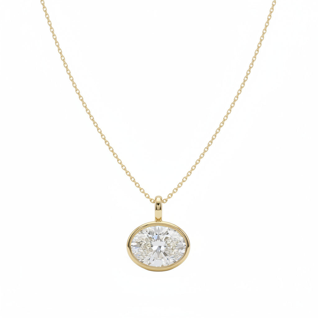 A yellow gold necklace with a oval bezel east-west set diamond, shown against a plain white background.

