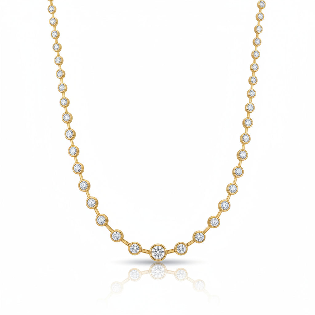 A yellow gold tennis necklace featuring a row of small bezel-set round spaced out diamonds with one larger central diamond at the center front, displayed on a clean white background with a soft reflection below.