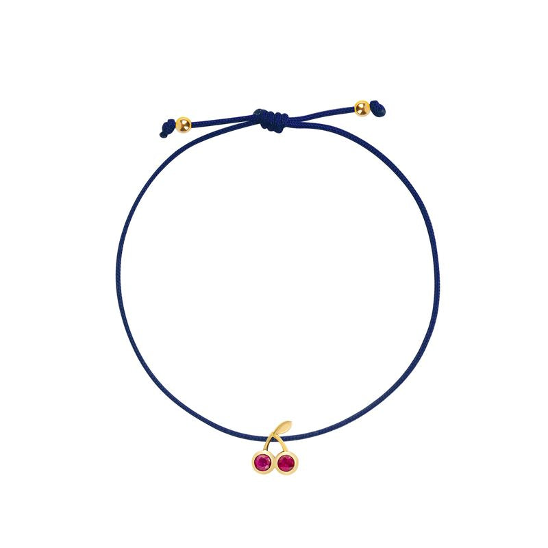 A navy blue cord bracelet with a gold-tone cherry charm featuring two small red gemstones, shown on a plain white background.