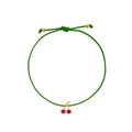 A green adjustable cord bracelet featuring a small gold-tone cherry charm with two pinkish-red gemstone centers, displayed on a clean white background.