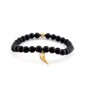 A beaded bracelet featuring matte black round beads, a small gold spacer bead, and a textured gold horn charm, displayed on a clean white background.