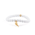 A white beaded stretch bracelet with a small gold horn charm and a single gold accent bead, shown on a clean white background.