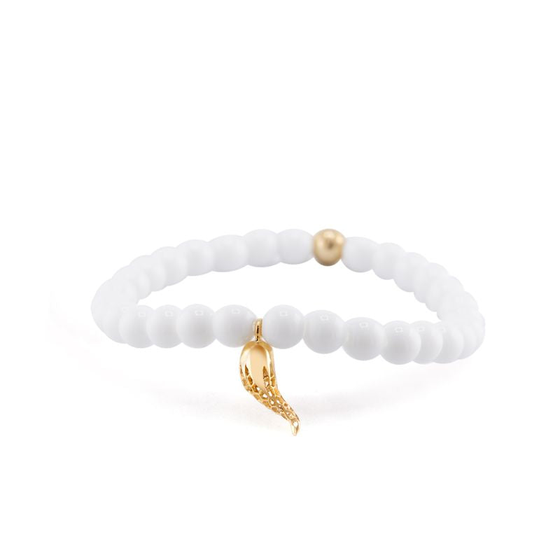 A white beaded stretch bracelet with a small gold horn charm and a single gold accent bead, shown on a clean white background.