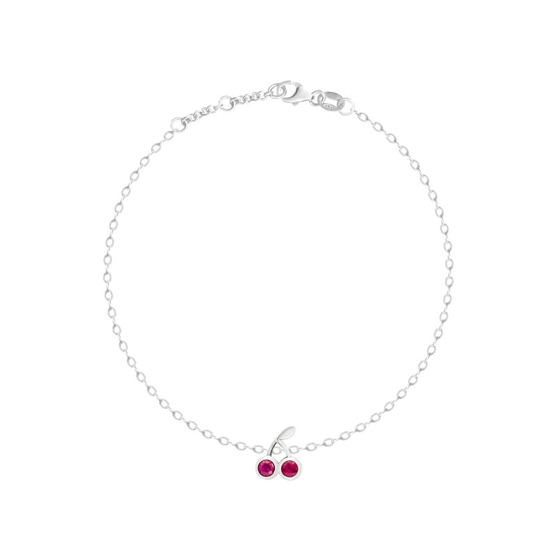 A delicate white gold chain bracelet with a small cherry charm featuring two red gemstones, displayed on a clean white background.