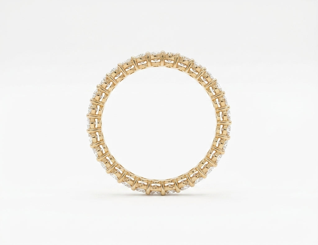 Underside basket view of 14k yellow gold oval diamond eternity ring on white bacground.