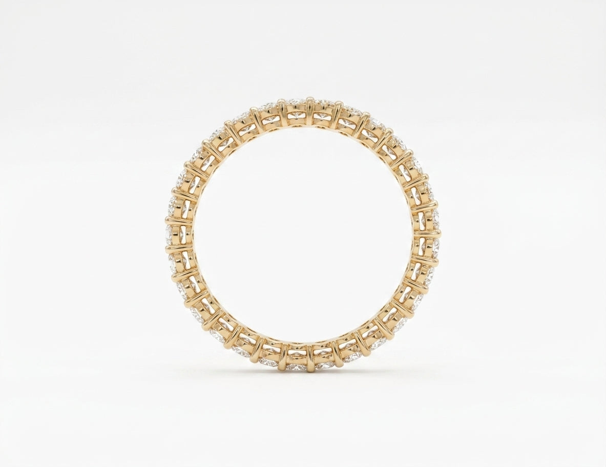 Underside basket view of 14k yellow gold oval diamond eternity ring on white bacground.