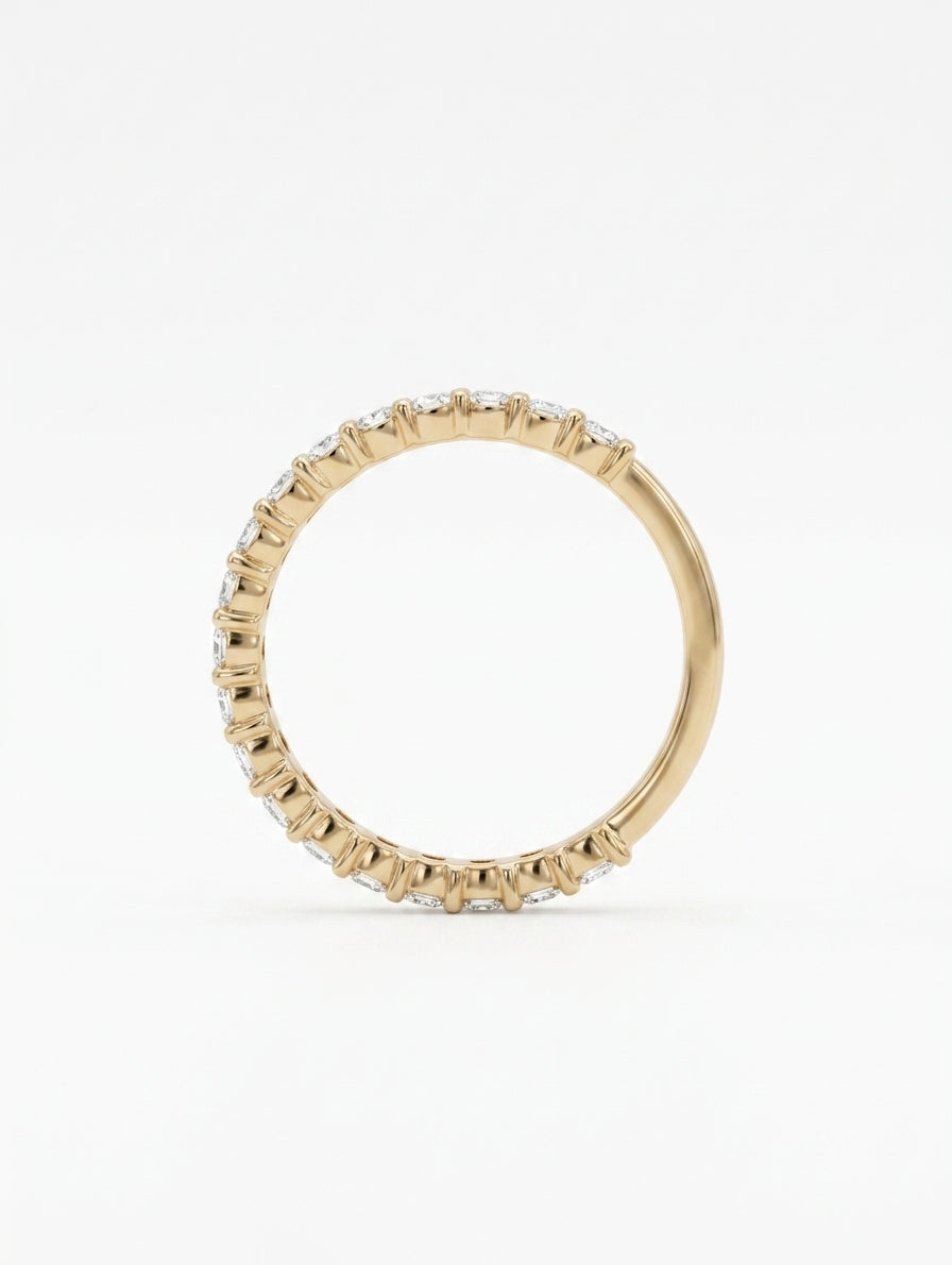 Side profile view of 14k yellow gold 3/4 eternity emerald cut lab diamond wedding ring on a white background.