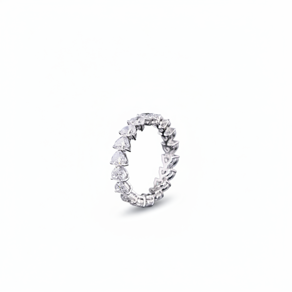 A white gold diamond eternity band ring featuring a continuous row of Heart Shaped-cut lab grown diamonds set in a polished silver-colored metal, shown against a plain white background.