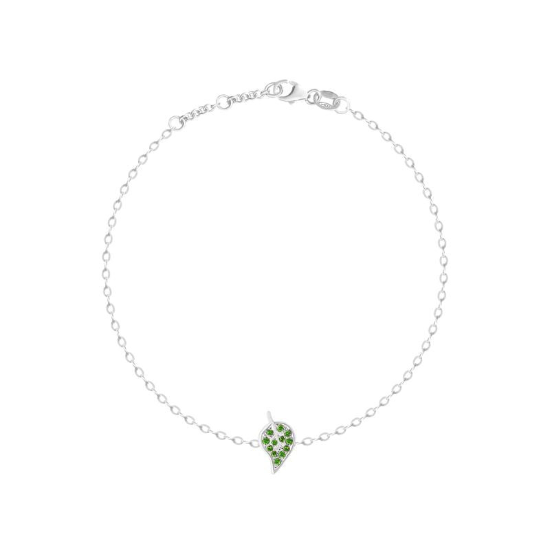 A delicate white gold chain bracelet with a small leaf-shaped charm paved with green stones, displayed on a clean white background.