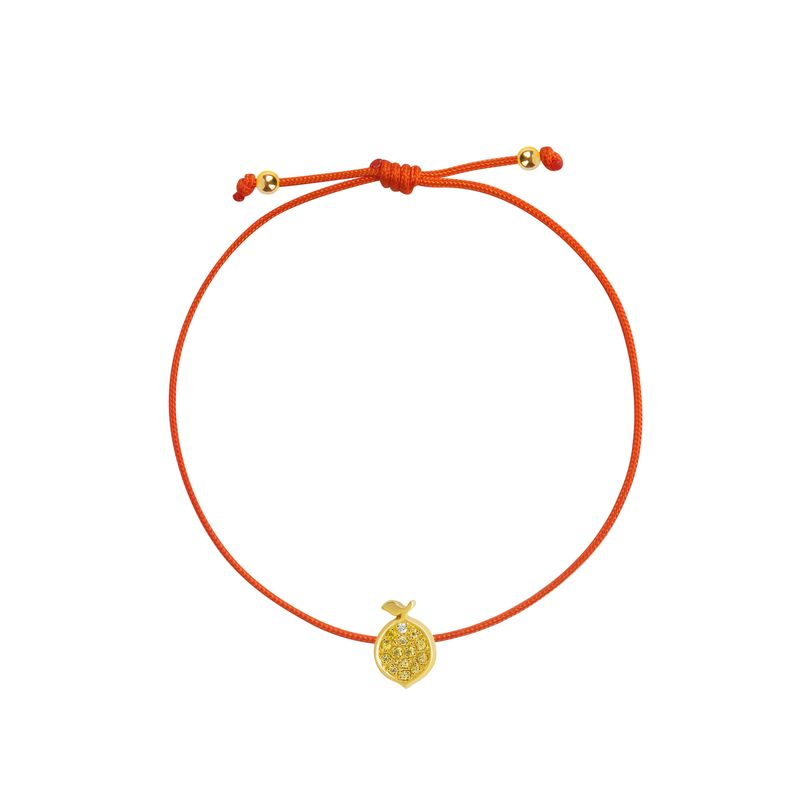 A delicate orange cord bracelet featuring a small textured yellow gold lemon charm and adjustable sliding knot with gold accent beads, shown on a plain white background.