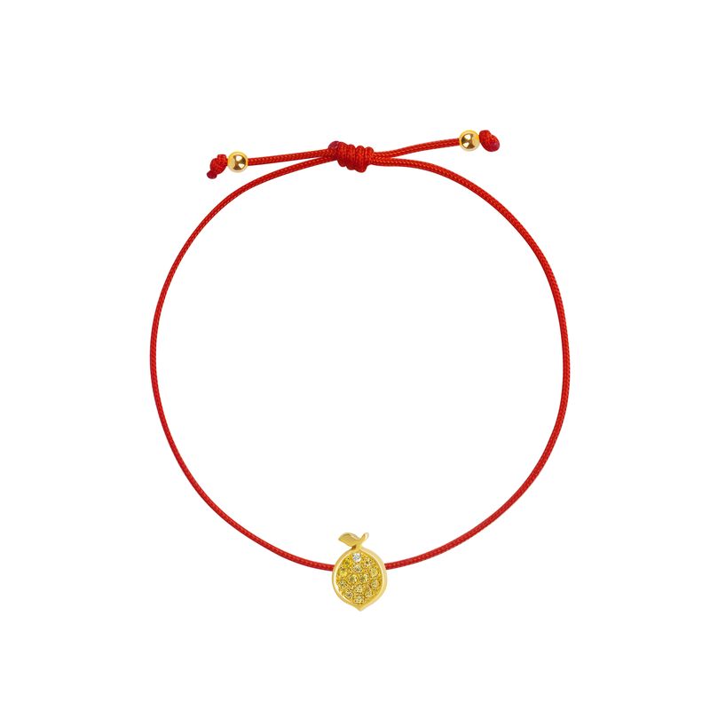 A delicate red cord bracelet featuring a small textured yellow gold lemon charm and adjustable sliding knot with gold accent beads, shown on a plain white background.