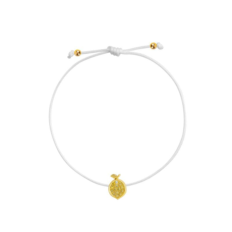A delicate white cord bracelet featuring a small textured yellow gold lemon charm and adjustable sliding knot with gold accent beads, shown on a plain white background.