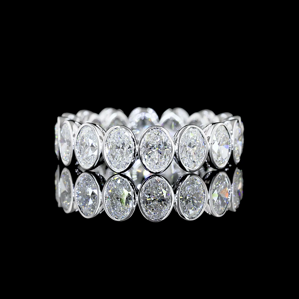 A white gold Oval Diamond Bezel set eternity ring featuring a continuous row of Oval lab grown diamonds, shown on a clean black background.