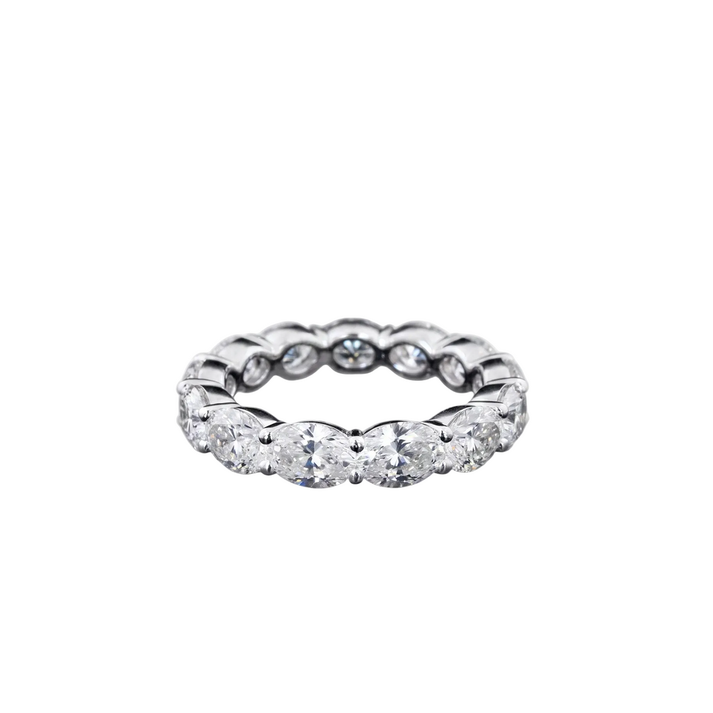 A white gold eternity ring featuring a continuous row of oval-cut lab grown diamonds, photographed on a seamless white background.