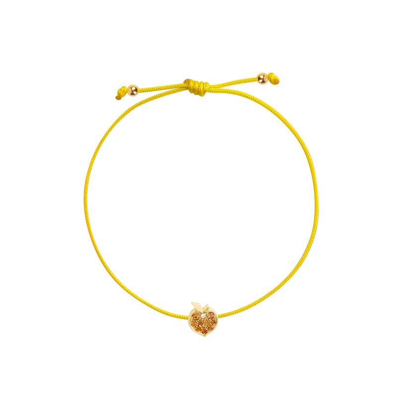 A yellow cord bracelet featuring a small gold peach-shaped charm adorned with tiny orange stones, presented on a solid white background.