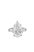 Diamond ring with pear-shaped center stone and tapered baquetes side diamonds on a white background.