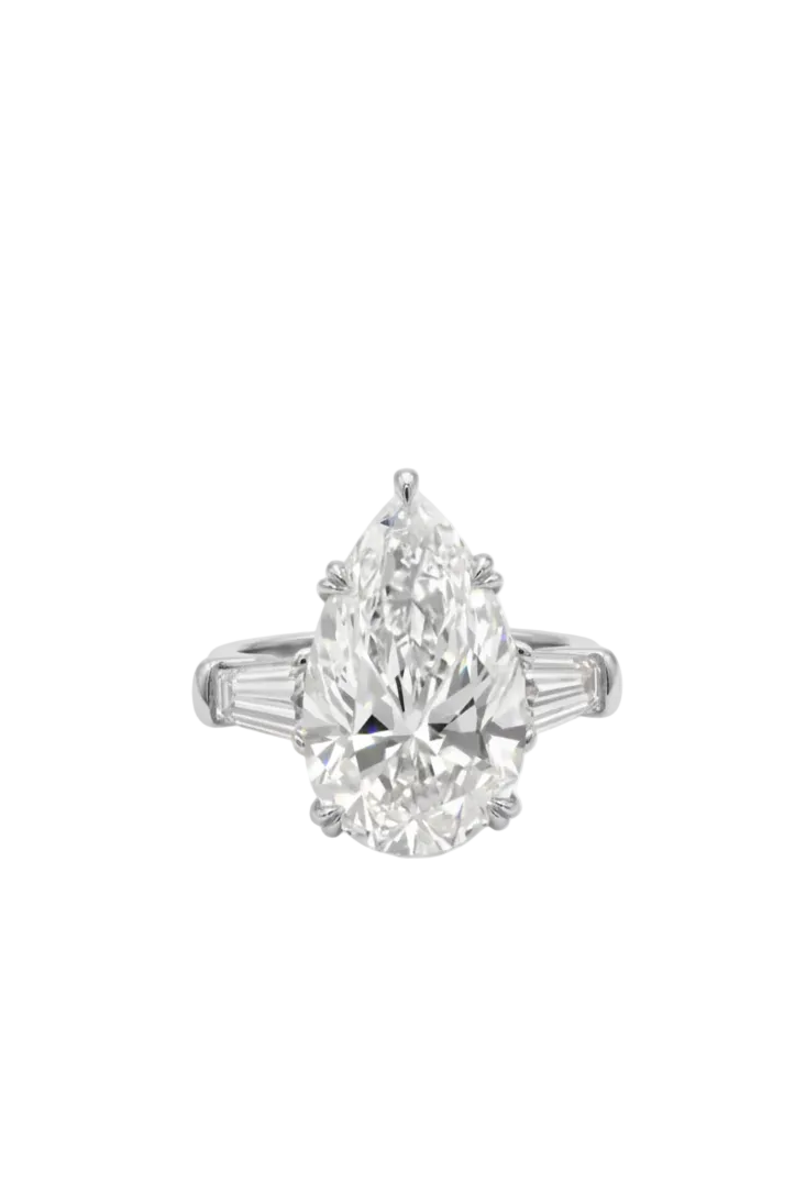 Diamond ring with pear-shaped center stone and tapered baquetes side diamonds on a white background.