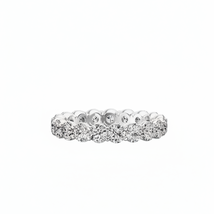 A diamond eternity ring in a silver-colored metal setting, featuring a continuous row of round brilliant-cut diamonds on a plain white background.