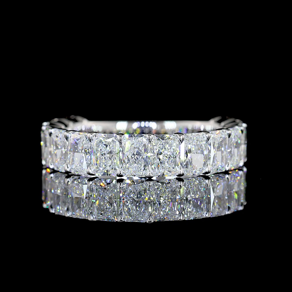 A white gold eternity ring featuring a  3/4 around the band, row of radiant-cut lab grown diamonds in a prong setting, shown on a plain white background.