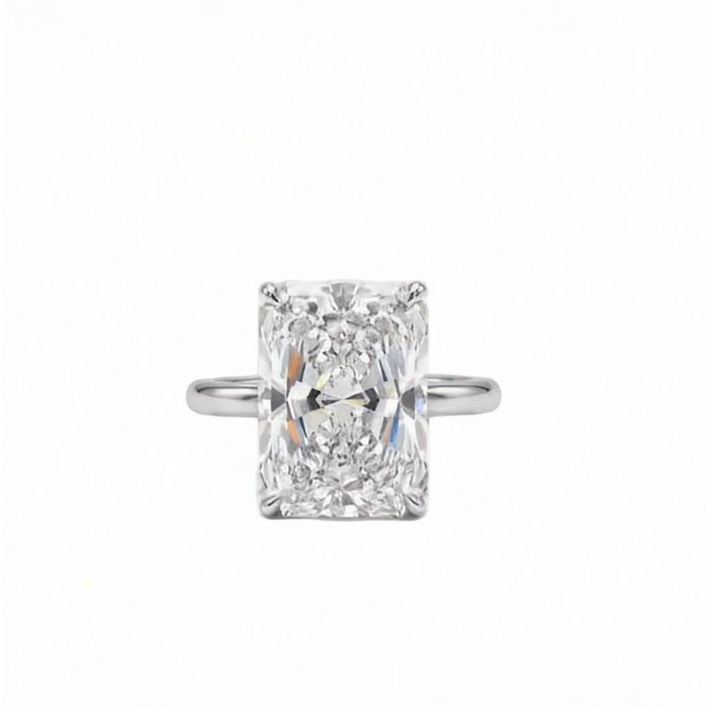 Platinum 5.06 carat radiant cut lab diamond solitaire engagement ring on 2mm band on a plain white background.