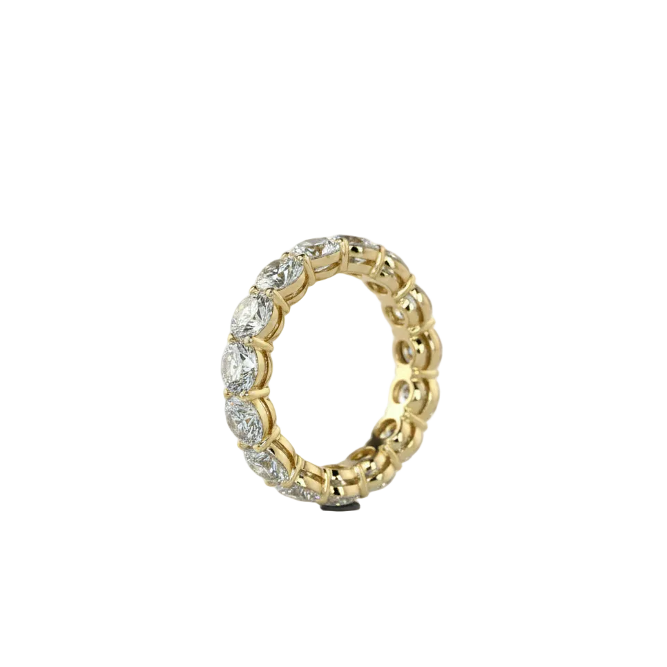 A yellow gold eternity ring featuring a continuous row of round-cut lab grown diamonds, shown on a plain white background.