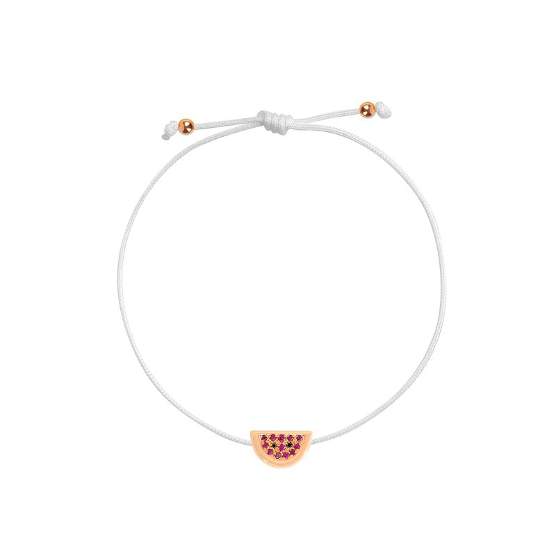 A delicate white cord bracelet with an adjustable sliding knot and a small watermelon slice charm featuring pinkish-red gemstones and a gold-tone outline, shown on a plain white background.