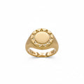 A yellow gold signet ring with a circular sunburst design on the face, featuring a brushed center and small cutout details around the border, shown on a plain white background.